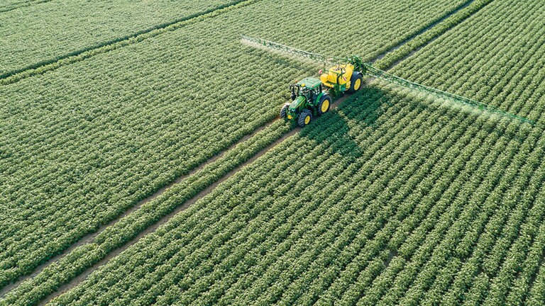 John Deere'i 6M-seeria traktor veab M700 jälveetavat põllupritsi kartulipõllul