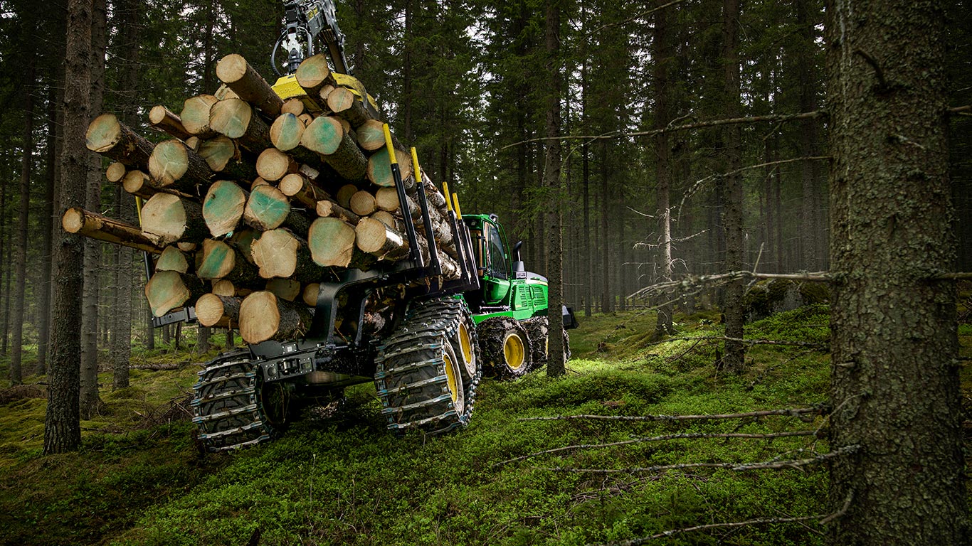 John Deere 910G ja puiduvirnad