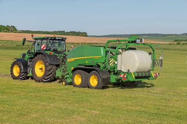 John Deere'i C442R rullipress-kiletaja, mida veab John Deere 6R 185, tehes suure tihedusega silorulle
