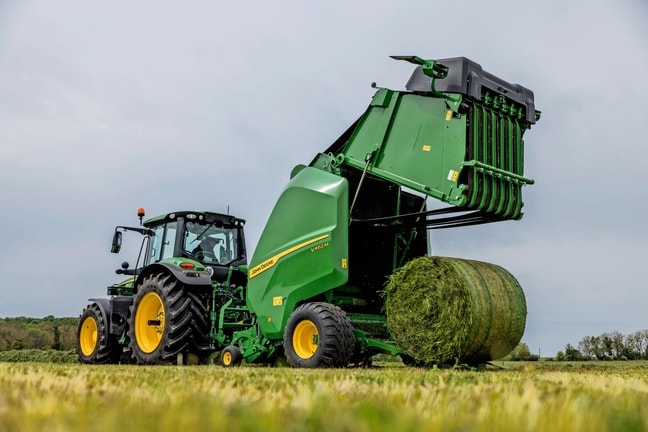 John Deere'i V462M rullipress, mida veab John Deere'i 6M traktor, väljastades heinapalli